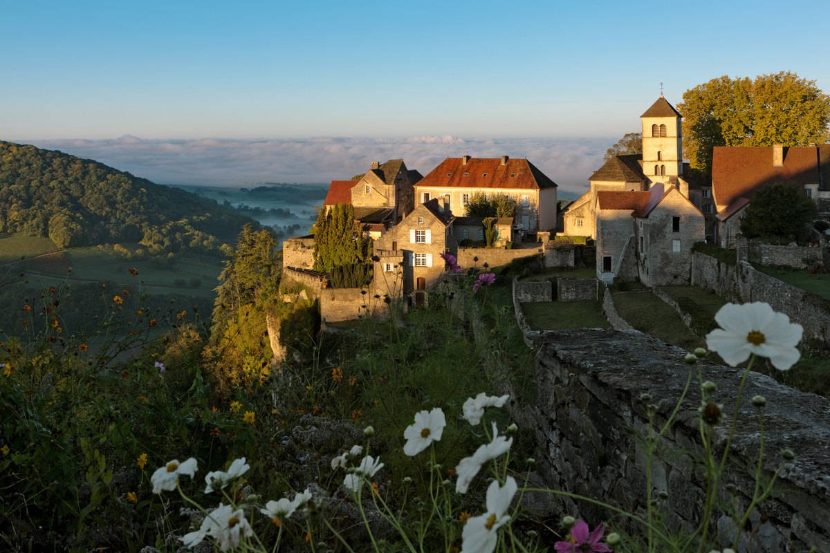 Le village de Château-Chalon au lever du jour, la brume posée sur la vallée en contrebas